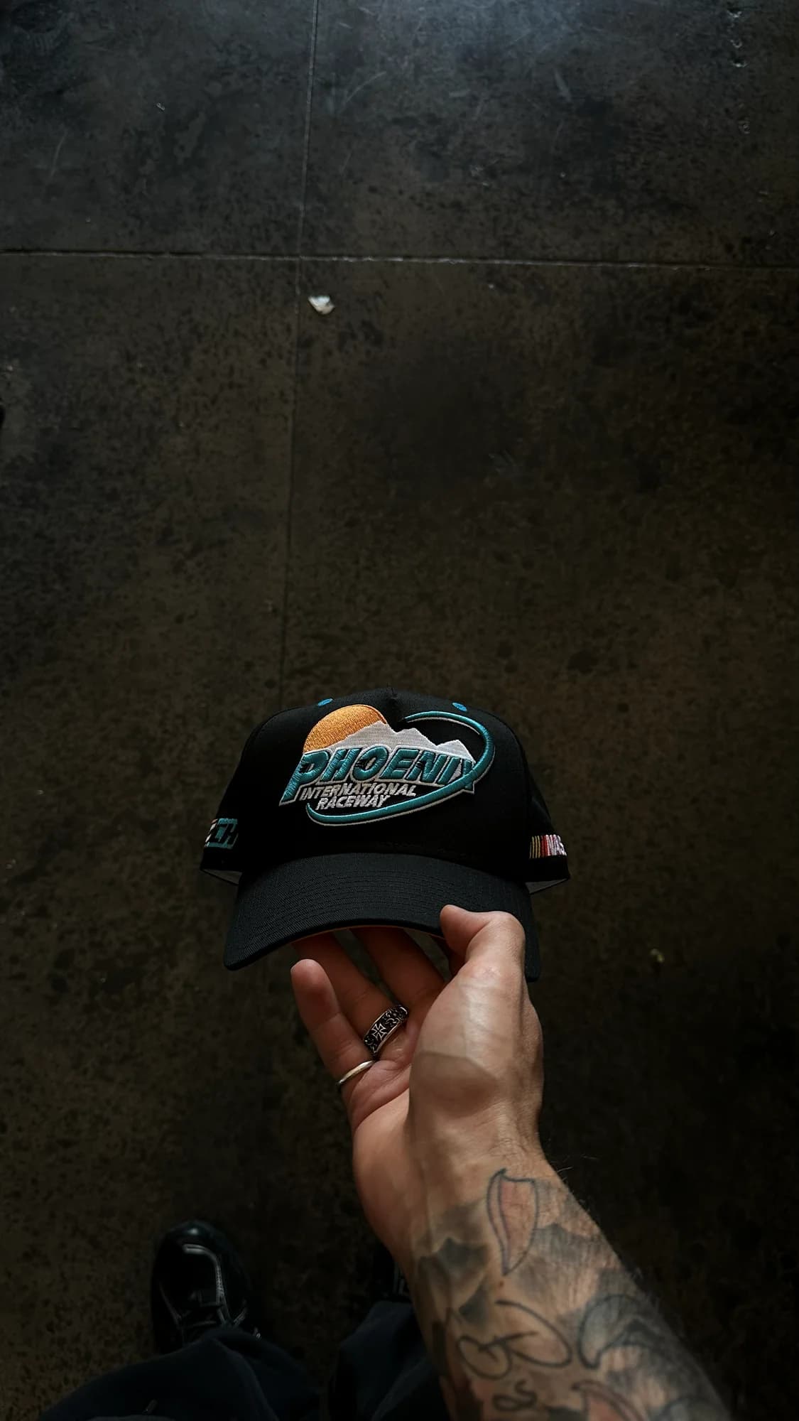 Black Common Hype NASCAR collaboration cap with embroidered Phoenix artwork