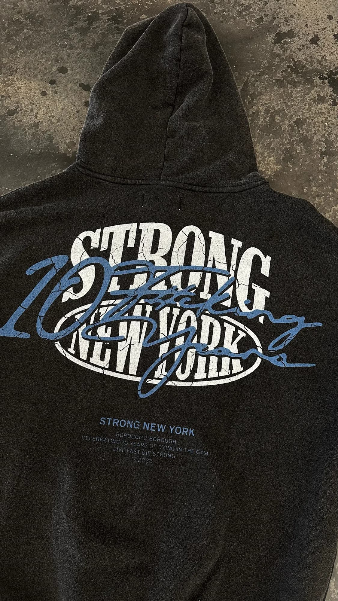 Black Strong New York hoodie with white lettering and blue anniversary graphics